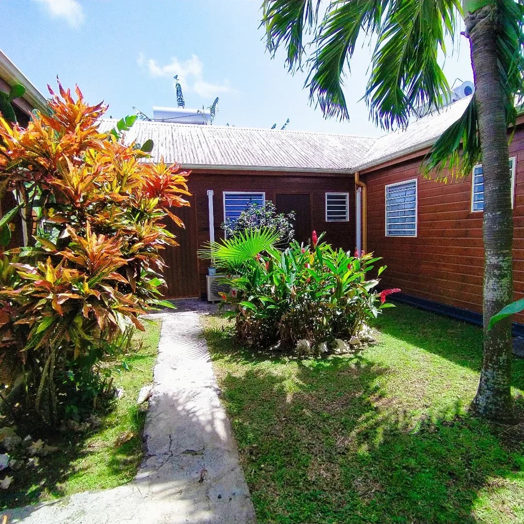 Les bungalows de Gwada Dream entourés de fleurs tropicales et de palmiers