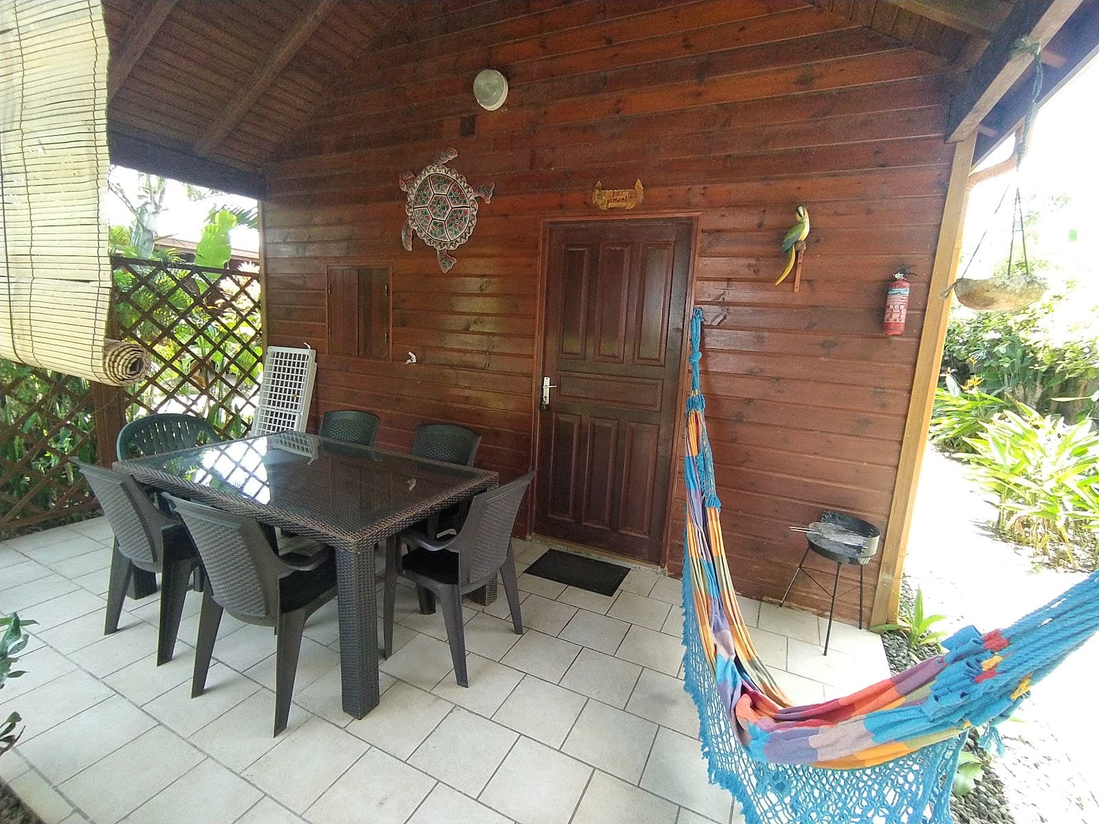 Terrasse couverte d'un bungalow en bois avec son hamac