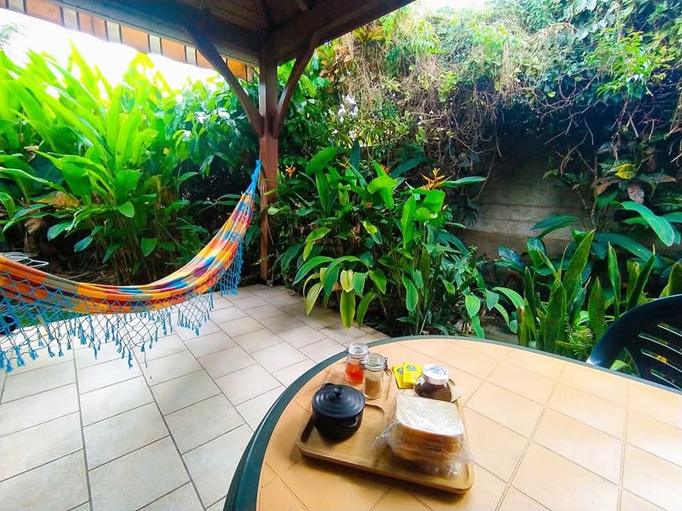 Patio avec hamac coloré et tables de jardin