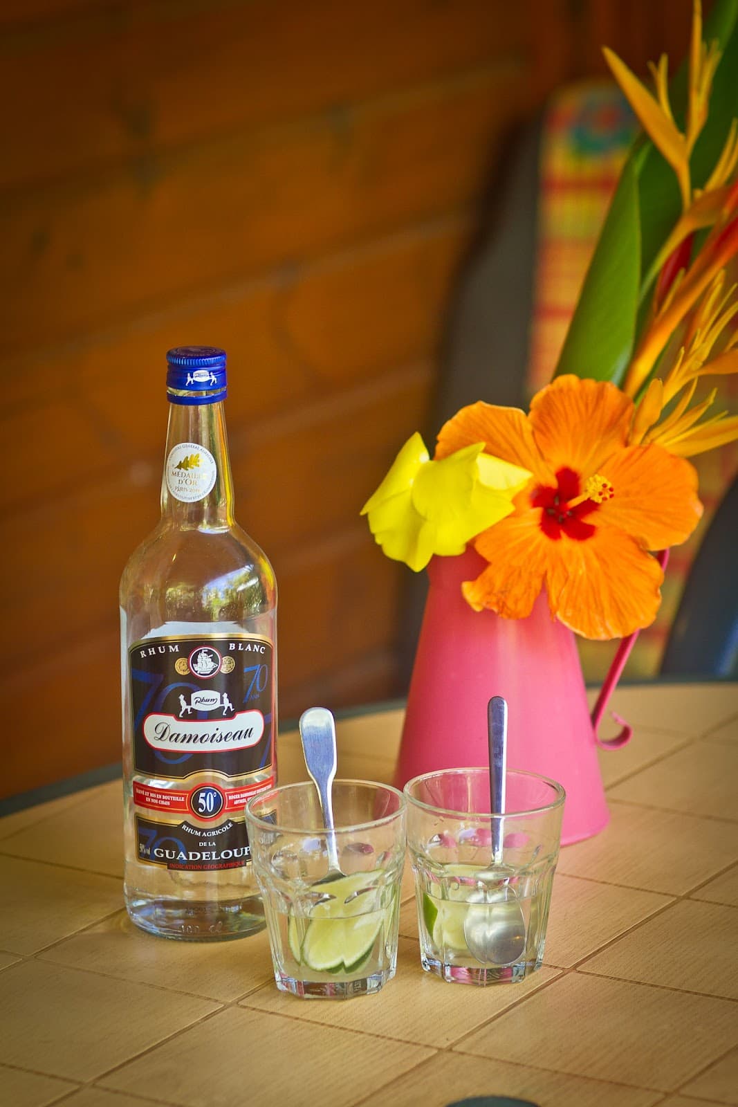 Bouteille de rhum, verres et fleurs orange